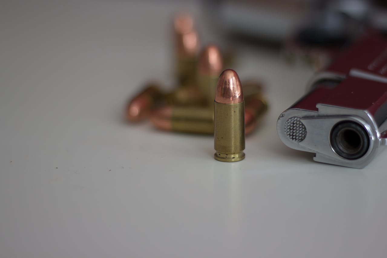 Unloaded pistol lying on the table next to ammunition.